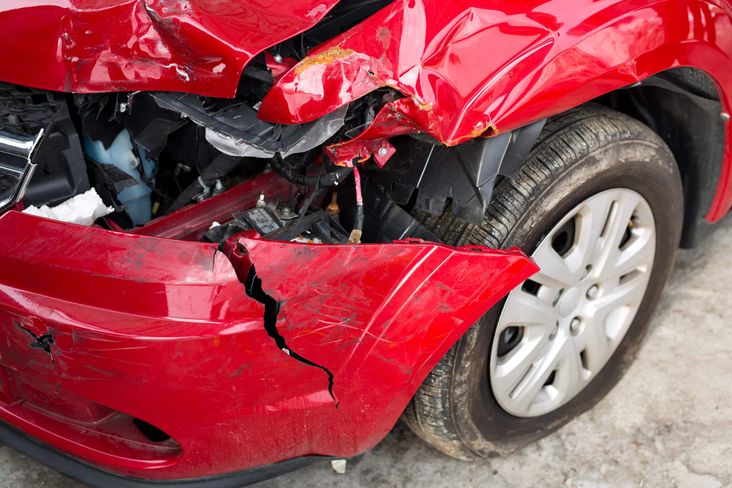 Damaged red car with severe dents